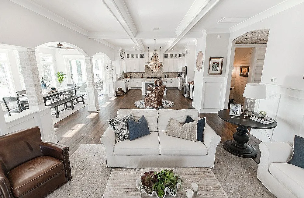 Spacious open-concept living area featuring light decor, a cozy seating arrangement, dining space, and modern kitchen; ideal for home builder inspirat