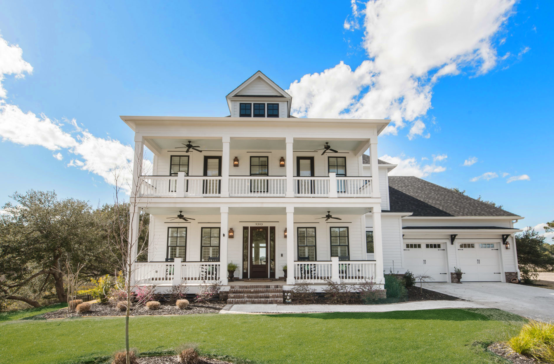 Elegant hallway with brick ceiling, dark wood floor, and white shiplap walls, leading to a glass front door. Designed by a home builder.