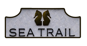 Logo with two seahorses above the text "Sea Trail," possibly representing a coastal home builder.