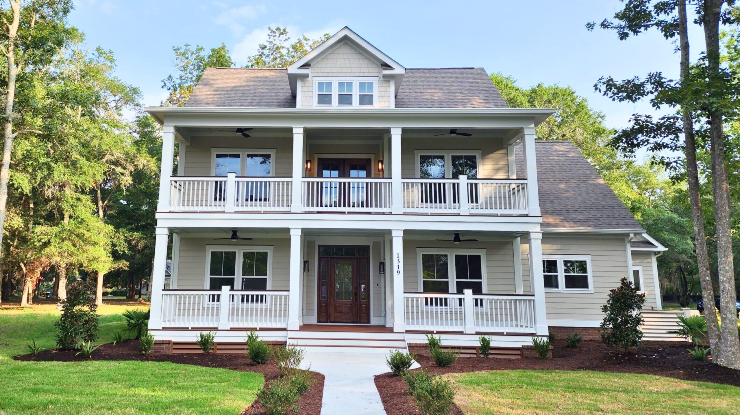 Elegant hallway with brick ceiling, dark wood floor, and white shiplap walls, leading to a glass front door. Designed by a home builder.