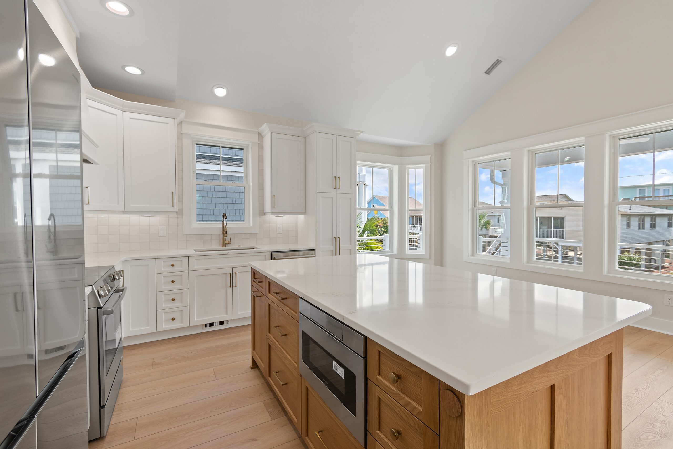 Elegant hallway with brick ceiling, dark wood floor, and white shiplap walls, leading to a glass front door. Designed by a home builder.